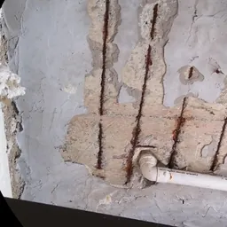Pilar com armadura exposta e concreto desagregado, exemplo de manifestação investigada em laudo