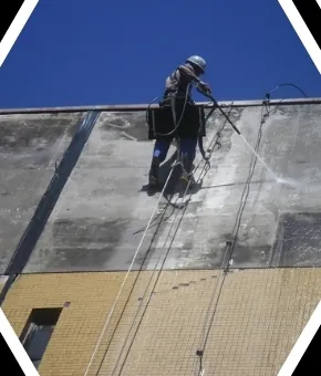 Profissional em rapel trabalhando na fachada de um edifício